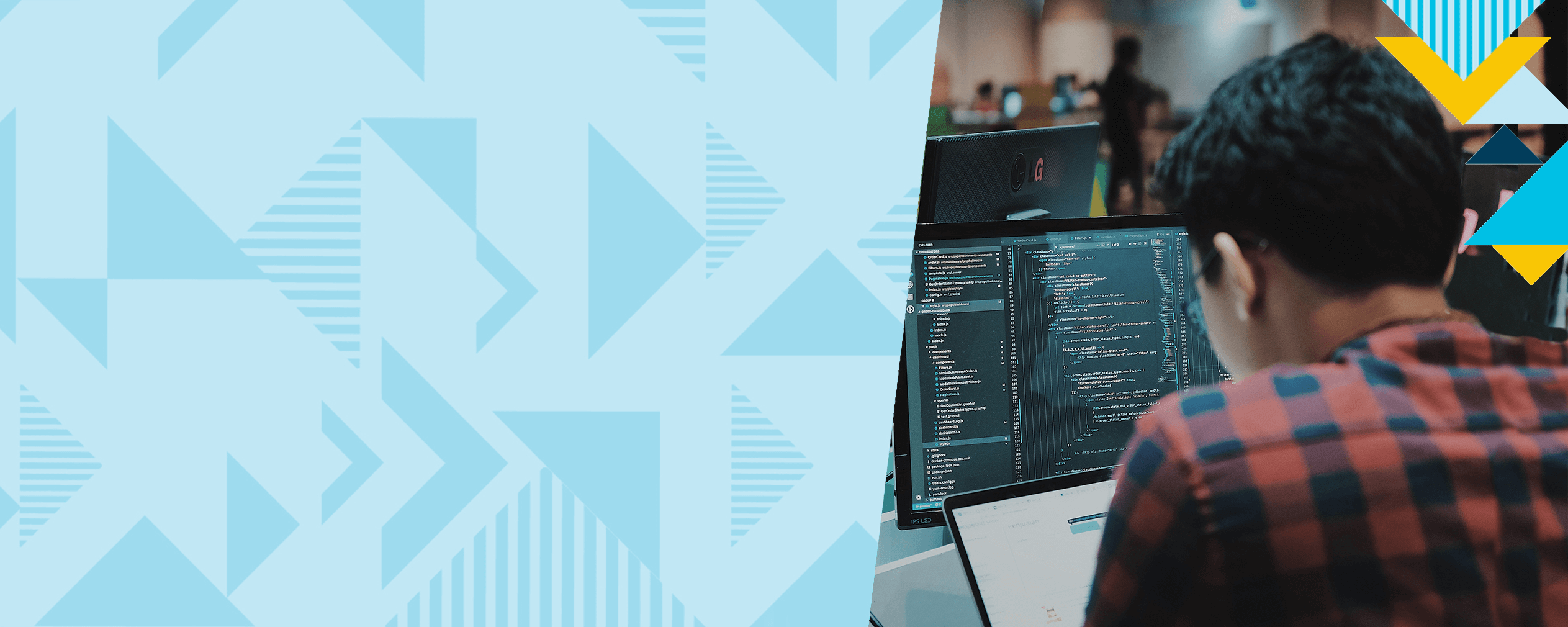 Capital One Tech associate with his back facing working on a monitor, with a two toned blue triangular background on the left